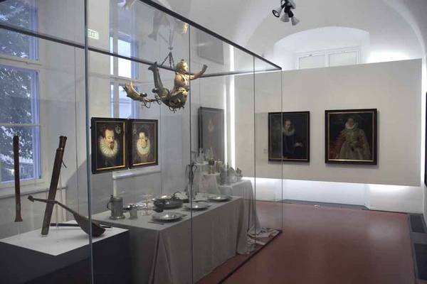 Tafelmusik, gedeckter Tisch und Schaubuffet umgeben von Porträts wohlhabender Salzburger des 17. Jahrhunderts